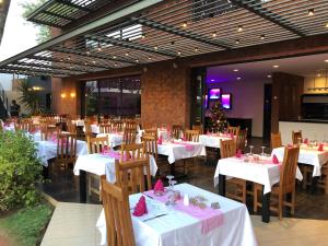 um restaurante com mesas brancas e cadeiras com guardanapos cor-de-rosa em KEPARANGA em Sali Poulang
