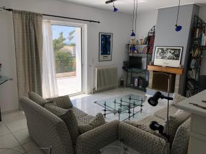 Saronida Art Apartment في Saronida: غرفة معيشة مع أريكة وطاولة زجاجية