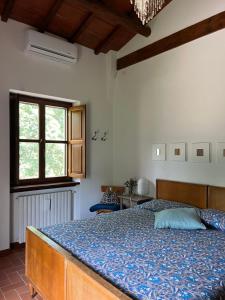 a bedroom with a bed with a blue comforter at La luna e i falò in Arezzo