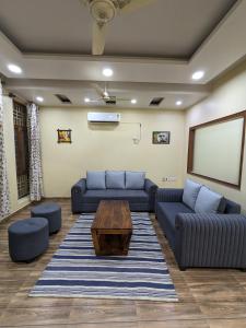 a living room with couches and a coffee table at Excellent Home Away from Home! in Noida