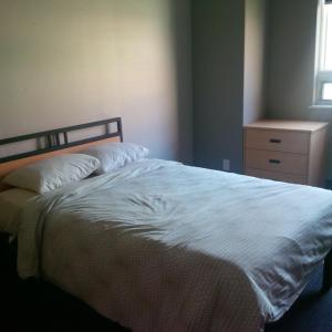 een bed met witte lakens en een dressoir in een slaapkamer bij Residence & Conference Centre - Oakville in Oakville