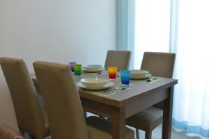 een tafel met stoelen en borden en drankjes erop bij Ferienwohnung für 3 Personen ca 55 qm in Alghero, Sardinien Sassarese in Alghero