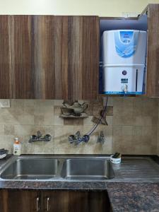 a kitchen counter with a sink and a dishwasher at Excellent Home Away from Home! in Noida