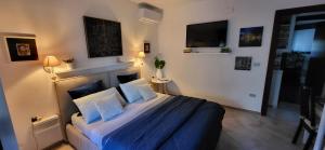 a bedroom with a bed with blue sheets and a tv at B&B Mare E Sole in Brindisi