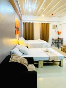a room with two beds and a couch in it at RAYMONDS LODGE in Manila