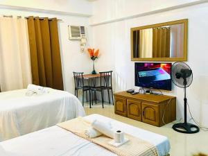 a room with two beds and a flat screen tv at RAYMONDS LODGE in Manila
