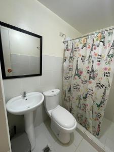 a bathroom with a sink and a toilet and a shower curtain at RAYMONDS LODGE in Manila