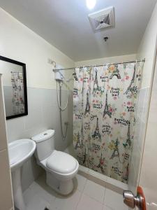 a bathroom with a toilet and a shower curtain at RAYMONDS LODGE in Manila