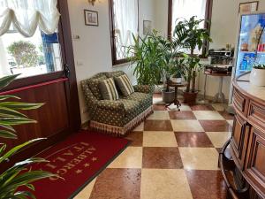 a living room with a chair and potted plants at Albergo Italia in Fossalta di Piave