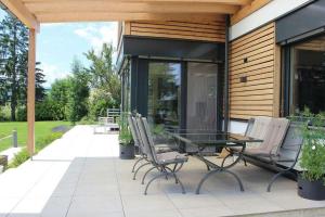 un patio con mesa de cristal y sillas en Villa am Red Bull Ring, en Knittelfeld