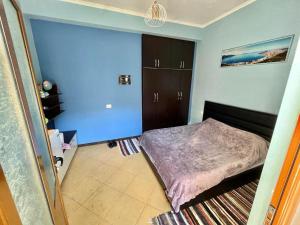 RENT ROOM -RENI - في Librazhd: غرفة نوم بسرير وجدار ازرق