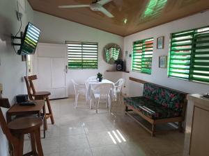 uma sala de jantar com mesa, cadeiras e janelas em Ortimar em Tolú