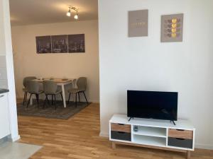 a living room with a tv and a table with chairs at Apartman Leo in Klinča Sela
