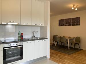 a kitchen with white cabinets and a table with chairs at Apartman Leo in Klinča Sela