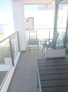uma varanda com cadeiras e mesas num edifício em Apartament vistes al mar em Llançà