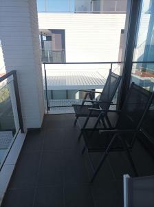 duas cadeiras sentadas na varanda de um edifício em Apartament vistes al mar em Llançà