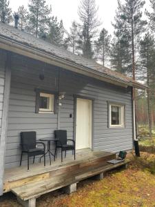 ein kleines Haus mit einem Tisch und Stühlen auf der Veranda in der Unterkunft Mökki Jyrkinkuja in Loimaa