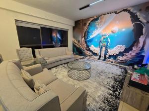 a living room with a large mural of an astronaut at 1 WORLD, Premium Hostel, JBR, Near Metro and Beach in Dubai