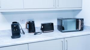 a counter with a microwave and other appliances on it at 1BR Sleeps 4, 3 mins from City centre & Local Gems in Burton upon Trent