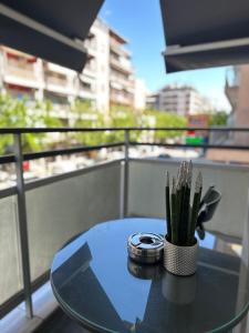 una mesa de cristal con una planta en el balcón en City Oasis, en Tesalónica