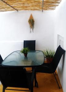 une table et des chaises en verre dans une pièce dans l'établissement Casa dos Marias, à Elvas