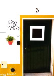 une porte noire et jaune avec une plante en pot dans l'établissement Casa dos Marias, à Elvas