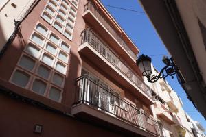 a building with a balcony and a street light at Aparthotel Pelicano in Benidorm