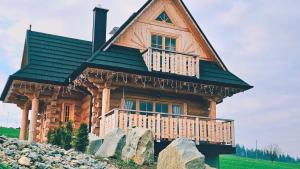 a log cabin with a green roof and a balcony at Jedlinowo Chata Domek Góralski in Szaflary