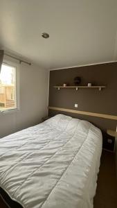 a bedroom with a white bed and a window at Camping Sable du Midi MH 6-8 personnes in Valras-Plage