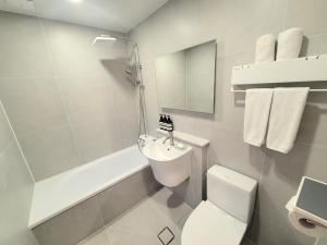 a bathroom with a sink and a toilet and a bath tub at Hotel Jeong Ansan Seonbu in Ansan