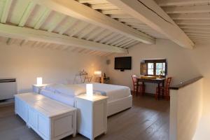 a bedroom with a white bed and a table at LA FORNACE in Asciano