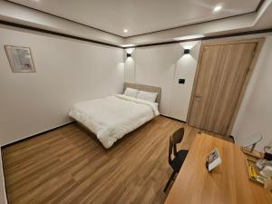 a bedroom with a bed and a desk and a table at Hotel Jeong Ansan Seonbu in Ansan