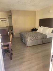 ein Hotelzimmer mit einem Bett und einem Schreibtisch in der Unterkunft Econo Lodge Las Vegas in Las Vegas