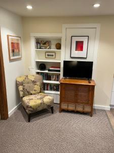a living room with a chair and a flat screen tv at Portland International Guesthouse in Portland