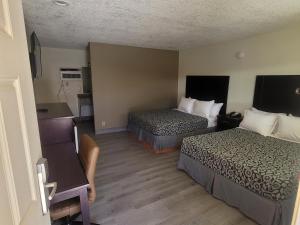 a hotel room with two beds and a desk at Econo Lodge Las Vegas in Las Vegas