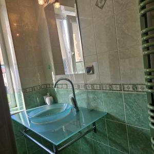 a bathroom with a glass sink and a mirror at Apartament Poranek in Grzybowo +3 photos