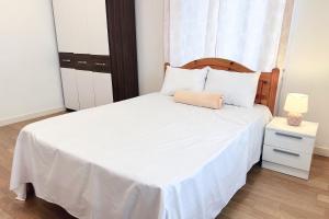 Schlafzimmer mit einem weißen Bett mit einem Kopfteil aus Holz in der Unterkunft Charming Villa with Private Pool in La Rotraite