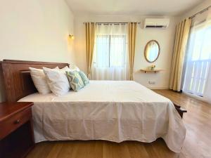 1 dormitorio con 1 cama con sábanas y almohadas blancas en Charming Villa with Private Pool, en La Rotraite