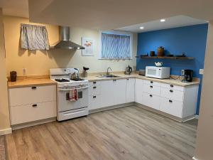 a kitchen with white appliances and a blue wall at Portland International Guesthouse in Portland