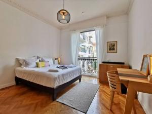 a bedroom with a bed and a desk and a window at Appartement Nice Bellecour in Nice