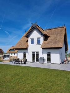 a large white house with a thatched roof at Reethaus Edith im Süden der Insel Rügen am Naturschutzgebiet - Eine Auszeit für Körper und Seele in Mellnitz