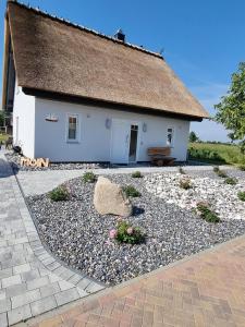 a small white building with a gravel yard at Reethaus Edith im Süden der Insel Rügen am Naturschutzgebiet - Eine Auszeit für Körper und Seele in Mellnitz