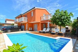 a villa with a swimming pool in front of a house at Ferienhaus mit Privatpool für 6 Personen ca 80 qm in Barbariga, Istrien Istrische Riviera in Barbariga