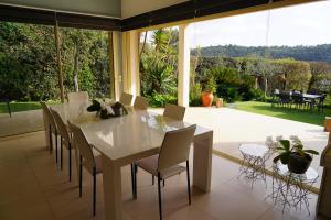 una sala da pranzo con tavolo e sedie bianchi di Villa de standing chambres climatisées avec piscine et jardin privatifs a Biot