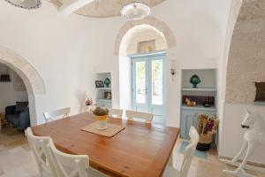 a kitchen and dining room with a wooden table and chairs at Trullo Dimora Podere Papilio in Noci