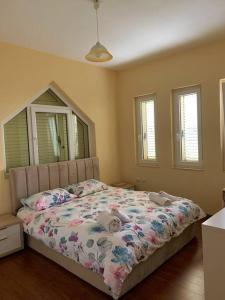 Natalia's House Surrel Villa في تيرانا: غرفة نوم مع سرير مع لحاف متهالك