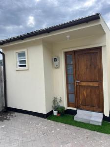 a house with a wooden door and a patio at Acogedor y confortable miniapartamento in Los Ángeles