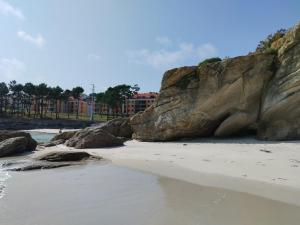 een strand met rotsen en zand en water bij 3 bedroom house near beach lighthouse hiking trail in Corme-Puerto