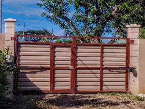 un grande cancello in legno con una recinzione di fronte di Santa Cruz Guanacaste CR a Santa Cruz