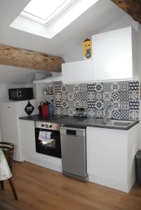 een keuken met een aanrecht en een fornuis bij Appartement cosy au deuxième étage in Malaucène